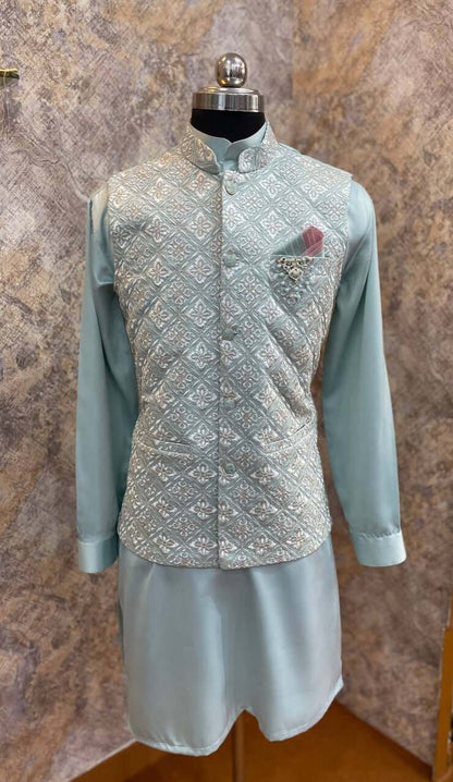 Aqua Blue Kurta jacket set for men is available online in india. The jacket is a cool aqua blue cotton satin with pretty floral and zari work. It has a mandarin collar and goes with matching blue hue cotton satin kurta & pants. This designer kurta set for men is perfect for weddings, parties, Diwali, Eid, Navratri & other traditional events. Shop this designer kurta jacket set for gents at Crease India Website.