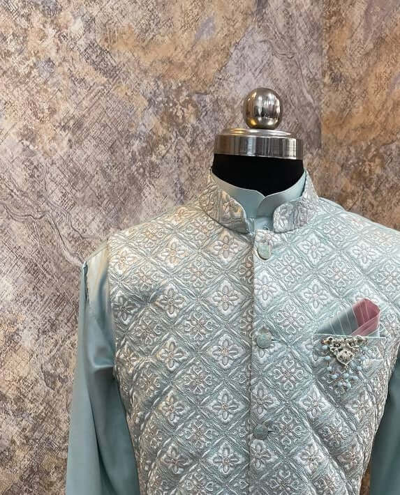 Aqua Blue Kurta jacket set for men is available online in india. The jacket is a cool aqua blue cotton satin with pretty floral and zari work. It has a mandarin collar and goes with matching blue hue cotton satin kurta & pants. This designer kurta set for men is perfect for weddings, parties, Diwali, Eid, Navratri & other traditional events. Shop this designer kurta jacket set for gents at Crease India Website.