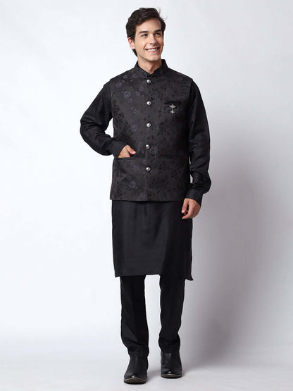 Black kurta jacket set for men available online in India. An elegant men's ethnic wear kurta jacket set with intricate black motifs design. The black jacket boasts a mandarin collar and complements the black kurta and pants, crafted from smooth dupion silk. This designer black kurta jacket set for men is ideal for weddings, Diwali, Eid, Navratri, & more festivals. Shop this designer black kurta set for men at Crease India Website.