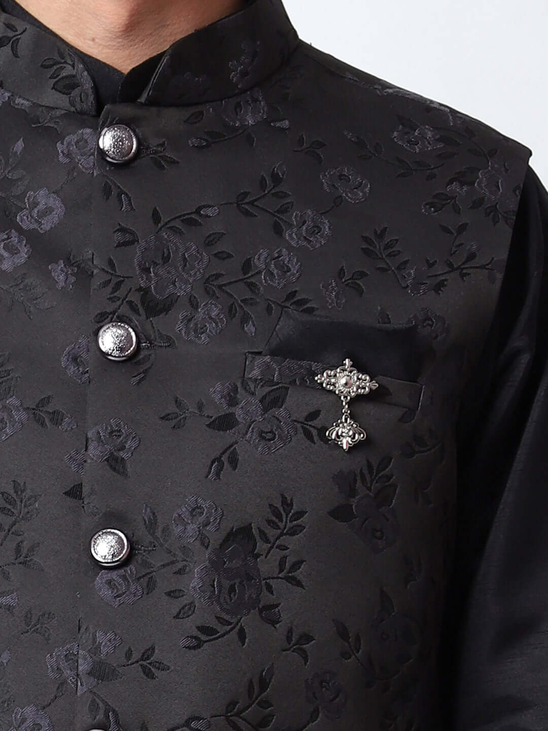 Black kurta jacket set for men available online in India. An elegant men's ethnic wear kurta jacket set with intricate black motifs design. The black jacket boasts a mandarin collar and complements the black kurta and pants, crafted from smooth dupion silk. This designer black kurta jacket set for men is ideal for weddings, Diwali, Eid, Navratri, & more festivals. Shop this designer black kurta set for men at Crease India Website.