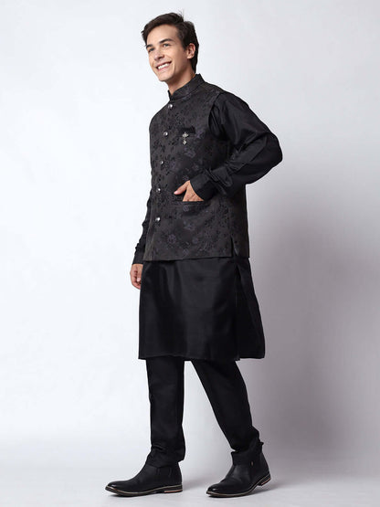 Black kurta jacket set for men available online in India. An elegant men's ethnic wear kurta jacket set with intricate black motifs design. The black jacket boasts a mandarin collar and complements the black kurta and pants, crafted from smooth dupion silk. This designer black kurta jacket set for men is ideal for weddings, Diwali, Eid, Navratri, & more festivals. Shop this designer black kurta set for men at Crease India Website.