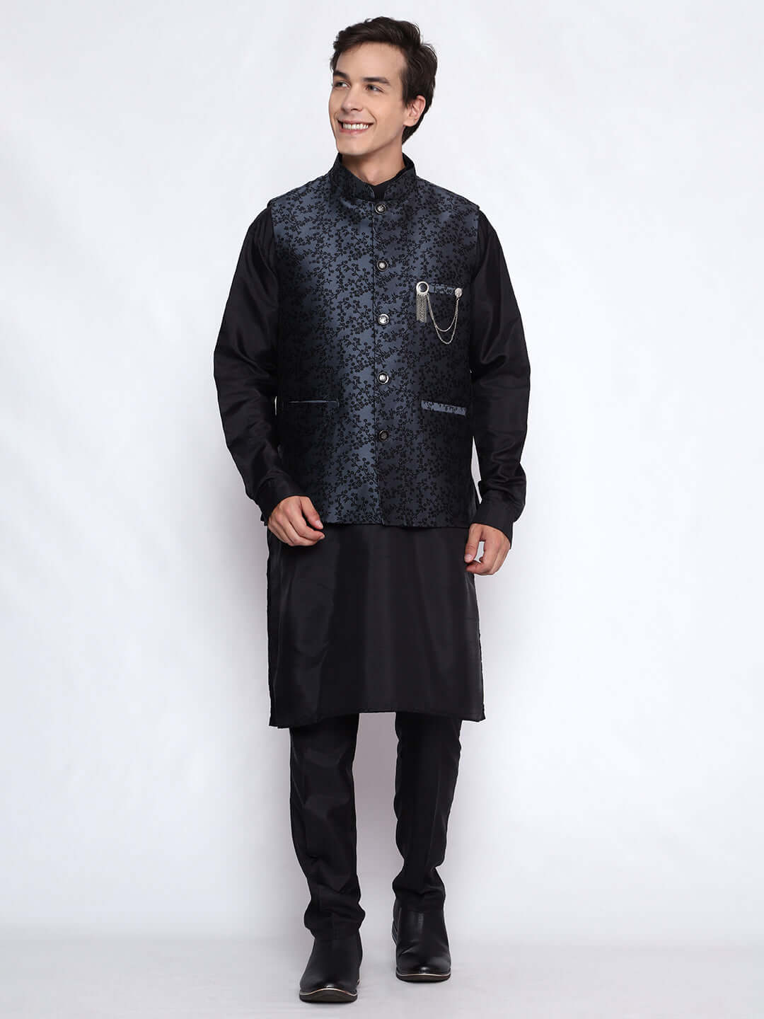 Grey kurta jacket set for men available online in India. An elegant men's ethnic wear kurta jacket set with intricate black floral embroidery design on grey jacquard jacket. The grey jacquard jacket boasts a mandarin collar and complements the black kurta and pants, crafted from smooth cotton silk. This designer grey jacquard kurta jacket set for men is ideal for weddings, Diwali, Eid, Navratri, & more festivals. Shop this designer grey & black kurta set for men at Crease India Website.