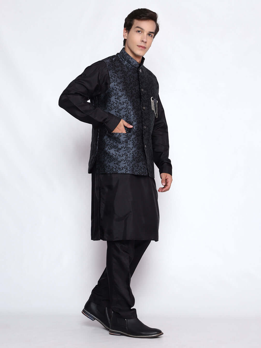 Grey kurta jacket set for men available online in India. An elegant men's ethnic wear kurta jacket set with intricate black floral embroidery design on grey jacquard jacket. The grey jacquard jacket boasts a mandarin collar and complements the black kurta and pants, crafted from smooth cotton silk. This designer grey jacquard kurta jacket set for men is ideal for weddings, Diwali, Eid, Navratri, & more festivals. Shop this designer grey & black kurta set for men at Crease India Website.