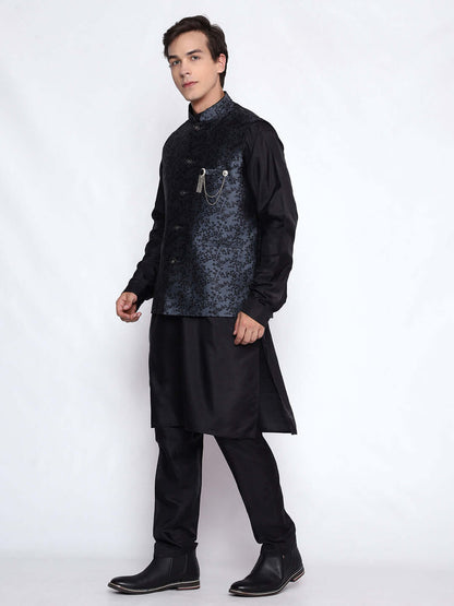 Grey kurta jacket set for men available online in India. An elegant men's ethnic wear kurta jacket set with intricate black floral embroidery design on grey jacquard jacket. The grey jacquard jacket boasts a mandarin collar and complements the black kurta and pants, crafted from smooth cotton silk. This designer grey jacquard kurta jacket set for men is ideal for weddings, Diwali, Eid, Navratri, & more festivals. Shop this designer grey & black kurta set for men at Crease India Website.