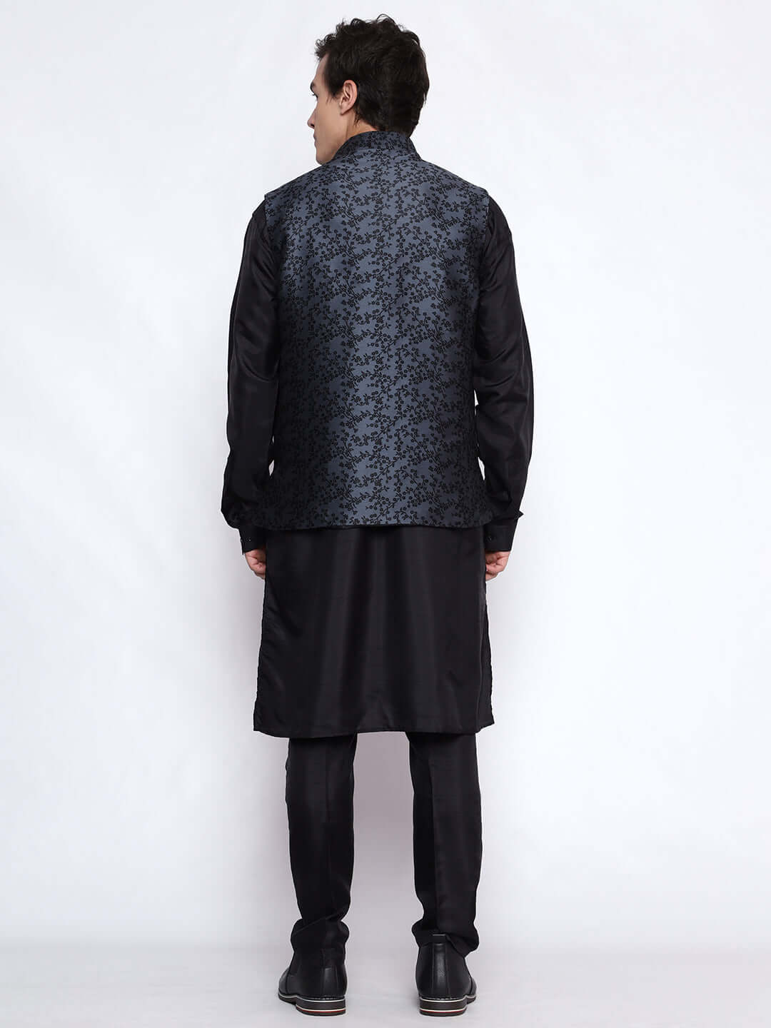 Grey kurta jacket set for men available online in India. An elegant men's ethnic wear kurta jacket set with intricate black floral embroidery design on grey jacquard jacket. The grey jacquard jacket boasts a mandarin collar and complements the black kurta and pants, crafted from smooth cotton silk. This designer grey jacquard kurta jacket set for men is ideal for weddings, Diwali, Eid, Navratri, & more festivals. Shop this designer grey & black kurta set for men at Crease India Website.