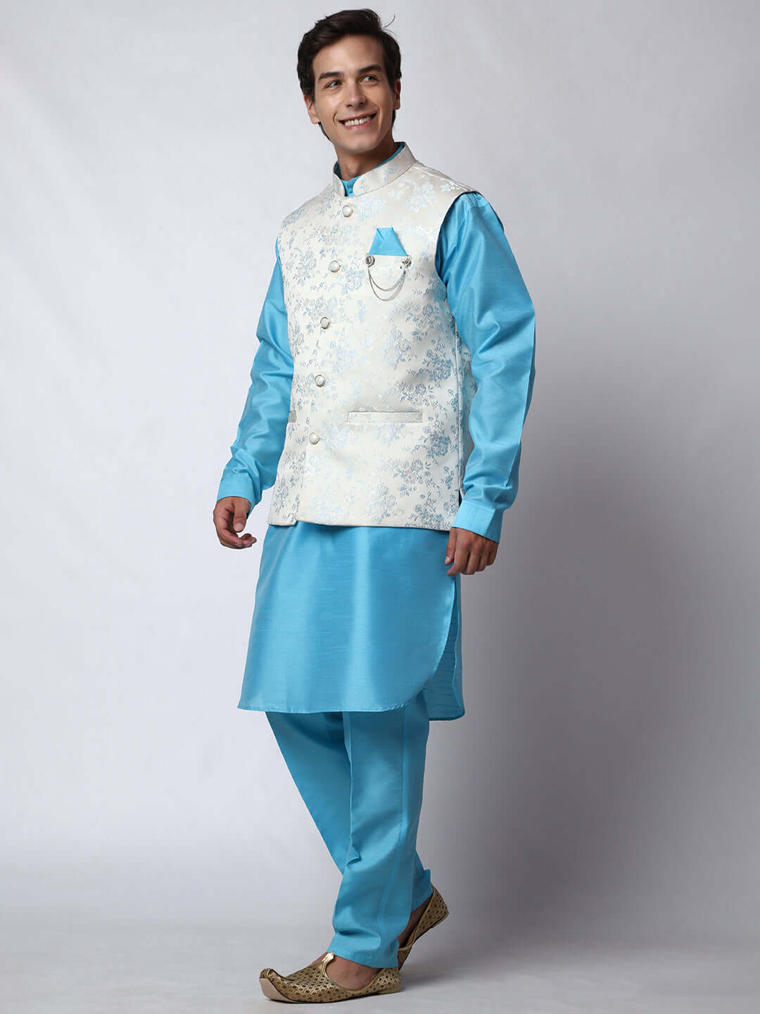 Blue kurta jacket set for men available online in India. An elegant men's ethnic wear kurta jacket set with intricate blue motifs design. The white jacquard jacket boasts a mandarin collar and complements the blue kurta and pants, crafted from smooth dupion silk. This designer blue kurta jacket set for men is ideal for weddings, Diwali, Eid, Navratri, & more festivals. Shop this designer blue kurta set for men at Crease India Website.