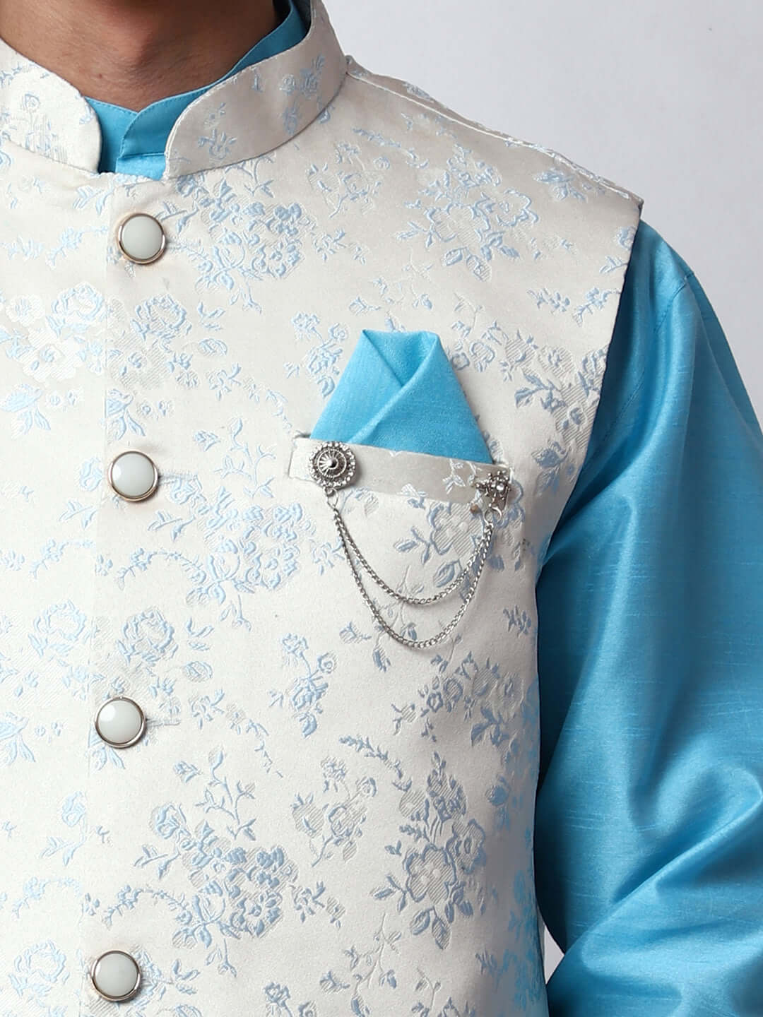 Blue kurta jacket set for men available online in India. An elegant men's ethnic wear kurta jacket set with intricate blue motifs design. The white jacquard jacket boasts a mandarin collar and complements the blue kurta and pants, crafted from smooth dupion silk. This designer blue kurta jacket set for men is ideal for weddings, Diwali, Eid, Navratri, & more festivals. Shop this designer blue kurta set for men at Crease India Website.