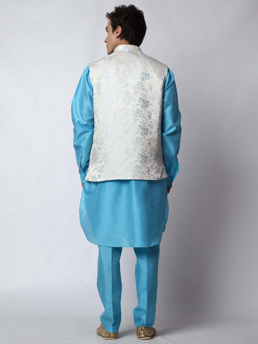 Blue kurta jacket set for men available online in India. An elegant men's ethnic wear kurta jacket set with intricate blue motifs design. The white jacquard jacket boasts a mandarin collar and complements the blue kurta and pants, crafted from smooth dupion silk. This designer blue kurta jacket set for men is ideal for weddings, Diwali, Eid, Navratri, & more festivals. Shop this designer blue kurta set for men at Crease India Website.