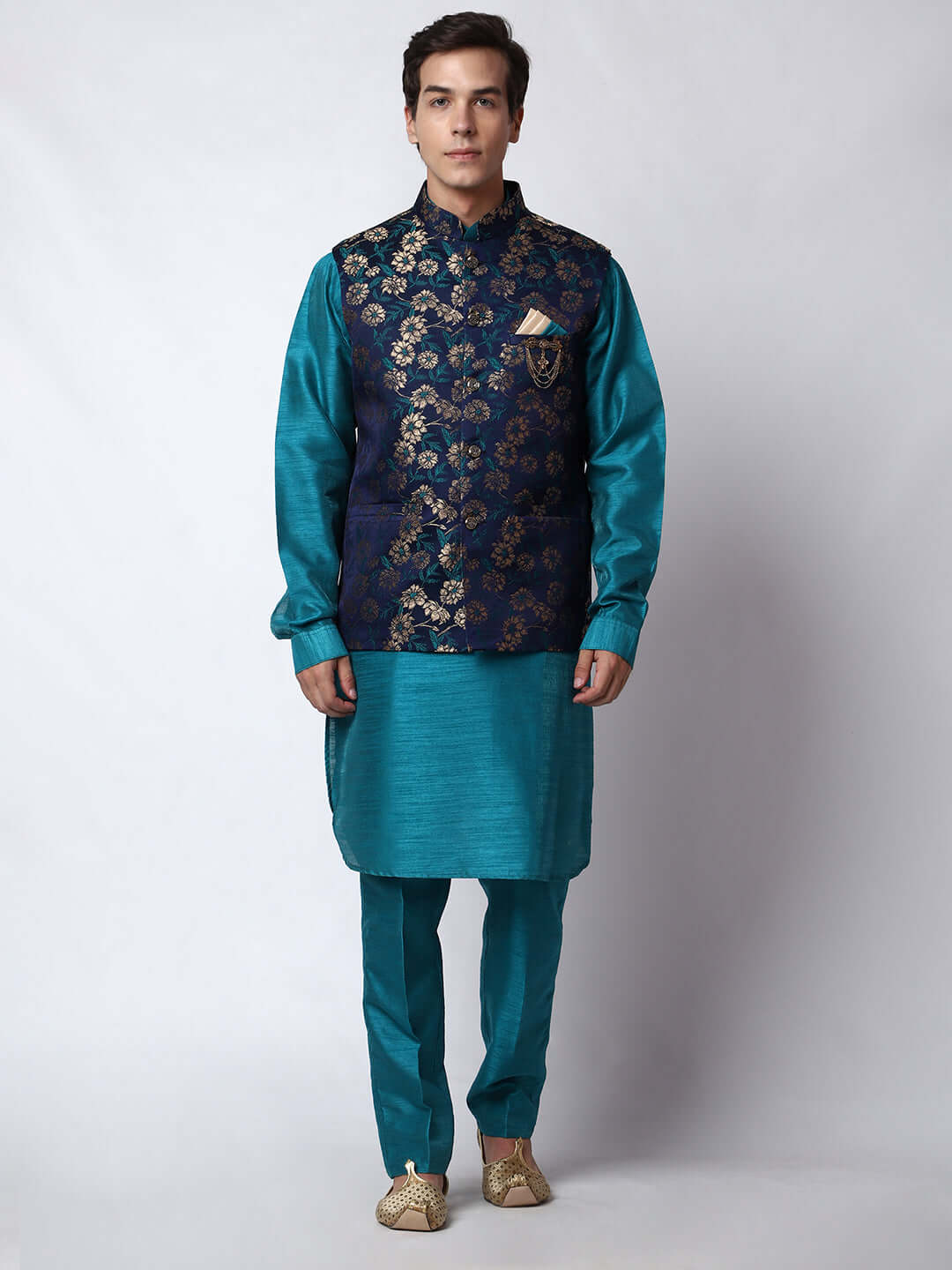 Turquoise Blue kurta jacket set for men available online in India. An elegant men's ethnic wear kurta jacket set with intricate golden floral embroidery. The sophisticated midnight blue jacket boasts a mandarin collar and complements the turquoise blue kurta and pants, crafted from smooth dupion silk. This designer kurta jacket set for men is ideal for weddings, Diwali, Eid, Navratri, & more festivals. Shop this designer kurta set for men on Crease India Website.