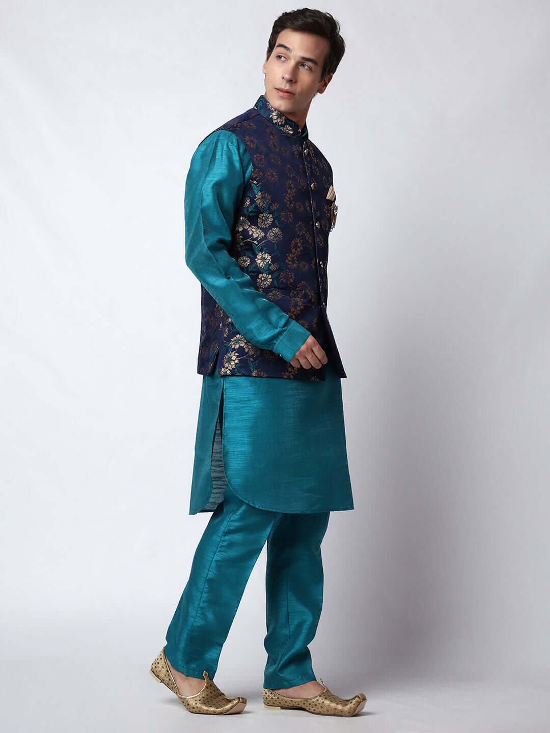 Turquoise Blue kurta jacket set for men available online in India. An elegant men's ethnic wear kurta jacket set with intricate golden floral embroidery. The sophisticated midnight blue jacket boasts a mandarin collar and complements the turquoise blue kurta and pants, crafted from smooth dupion silk. This designer kurta jacket set for men is ideal for weddings, Diwali, Eid, Navratri, & more festivals. Shop this designer kurta set for men on Crease India Website.