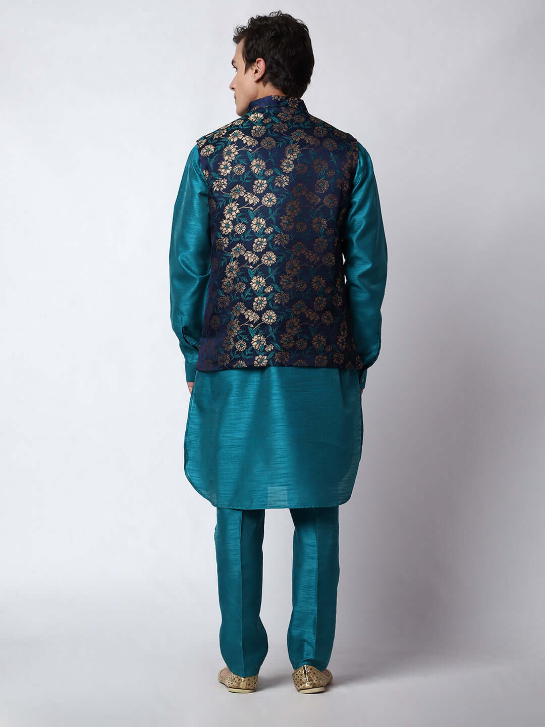 Turquoise Blue kurta jacket set for men available online in India. An elegant men's ethnic wear kurta jacket set with intricate golden floral embroidery. The sophisticated midnight blue jacket boasts a mandarin collar and complements the turquoise blue kurta and pants, crafted from smooth dupion silk. This designer kurta jacket set for men is ideal for weddings, Diwali, Eid, Navratri, & more festivals. Shop this designer kurta set for men on Crease India Website.