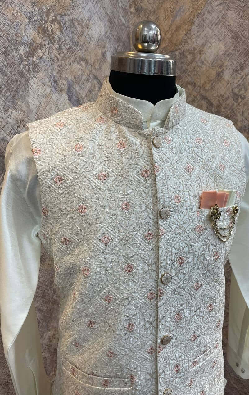 The Cream Kurta jacket set for men is available online in India. The jacket is made with a cream color jacquard silk and have multicolored threadword. It has a mandarin collar and goes with a matching cream hue dupion silk kurta &amp; pants. This cream designer kurta set for men is perfect for weddings, wedding functions, parties, Diwali, Eid, Navratri & other traditional events. Shop this designer kurta jacket set for gents at the Crease India Website.