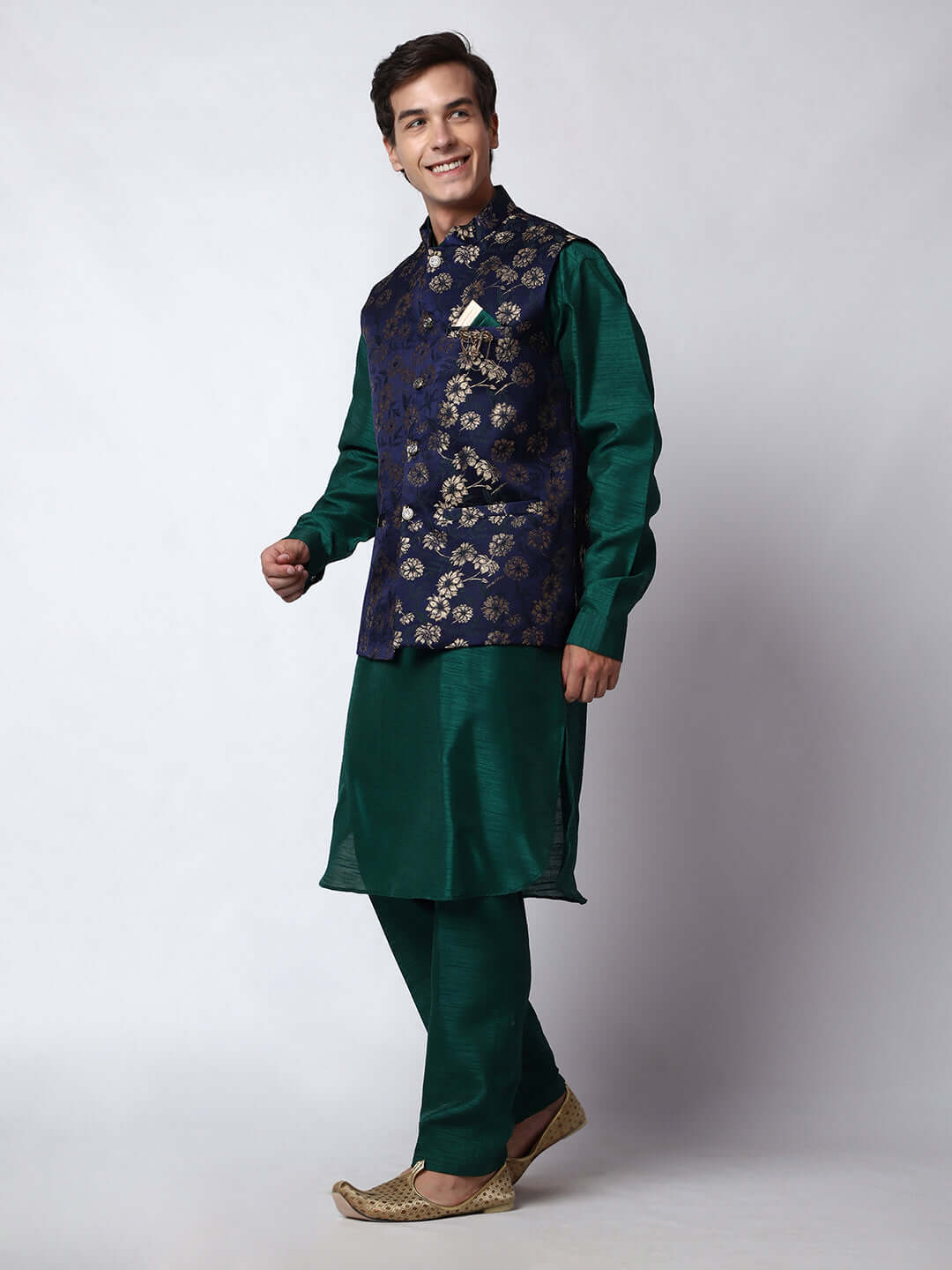 Dark Green kurta jacket set for men available online in India. An elegant men's ethnic wear kurta jacket set with intricate golden floral embroidery. The sophisticated midnight blue jacket boasts a mandarin collar and complements the dark green kurta and pants, crafted from smooth dupion silk. This designer kurta jacket set for men is ideal for weddings, Diwali, Eid, Navratri, & more festivals. Shop this designer kurta set for men on Crease India Website.