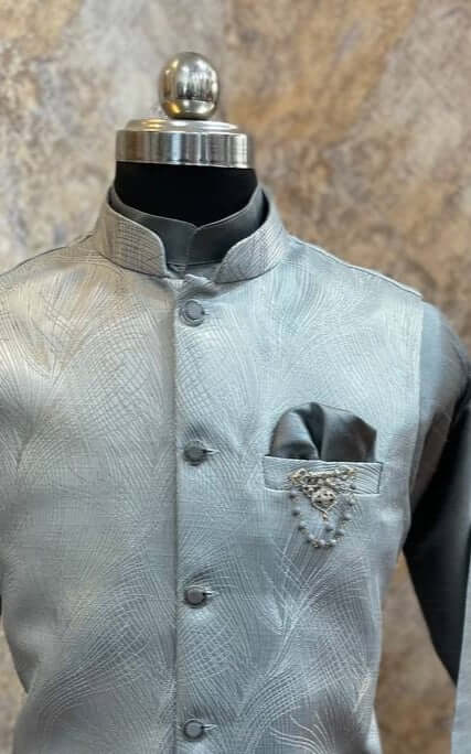 The Grey Kurta jacket set for men is available online in India. The jacket is made with a grey imported Italian jacquard fabric with abstract designs. It has a mandarin collar and goes with a matching grey hue cotton silk kurta & pants. This designer kurta set for men is perfect for weddings, parties, Diwali, Eid, Navratri & other traditional events. Shop this designer kurta jacket set for gents at the Crease India Website.