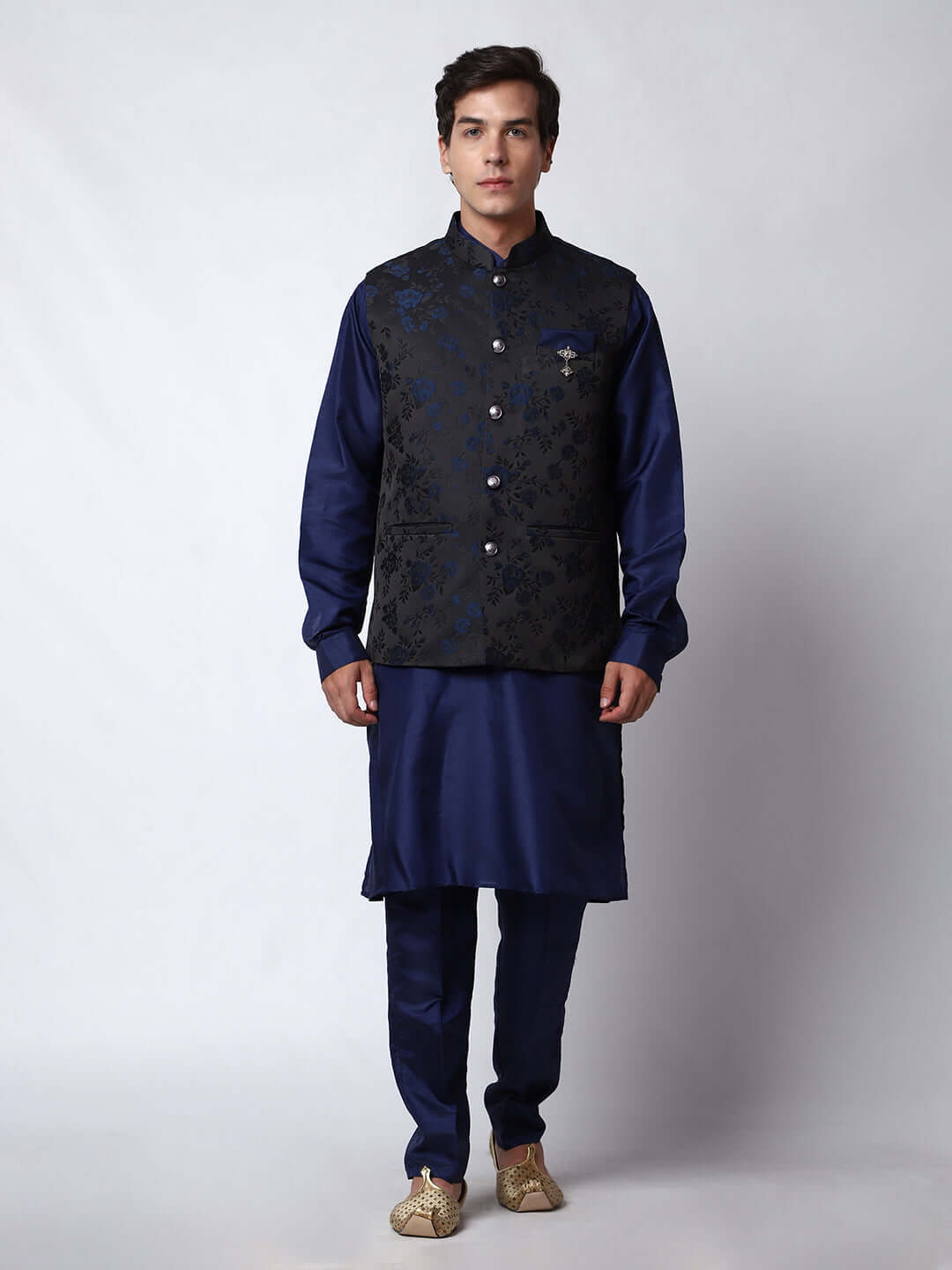 Navy Blue kurta jacket set for men available online in India. An elegant men's ethnic wear kurta jacket set with intricate floral work on black jacquard silk jacket. The black jacket boasts a mandarin collar and complements the navy blue kurta and pants, crafted from smooth cotton silk. This navy blue designer kurta jacket set for men is ideal for weddings, Diwali, Eid, Navratri, & other traditional events. Shop this navy blue designer kurta set for men on Crease India Website.