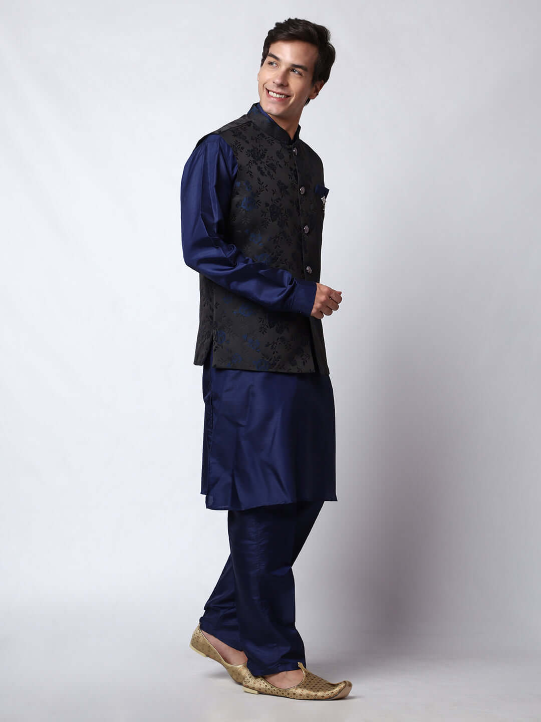 Navy Blue kurta jacket set for men available online in India. An elegant men's ethnic wear kurta jacket set with intricate floral work on black jacquard silk jacket. The black jacket boasts a mandarin collar and complements the navy blue kurta and pants, crafted from smooth cotton silk. This navy blue designer kurta jacket set for men is ideal for weddings, Diwali, Eid, Navratri, & other traditional events. Shop this navy blue designer kurta set for men on Crease India Website.