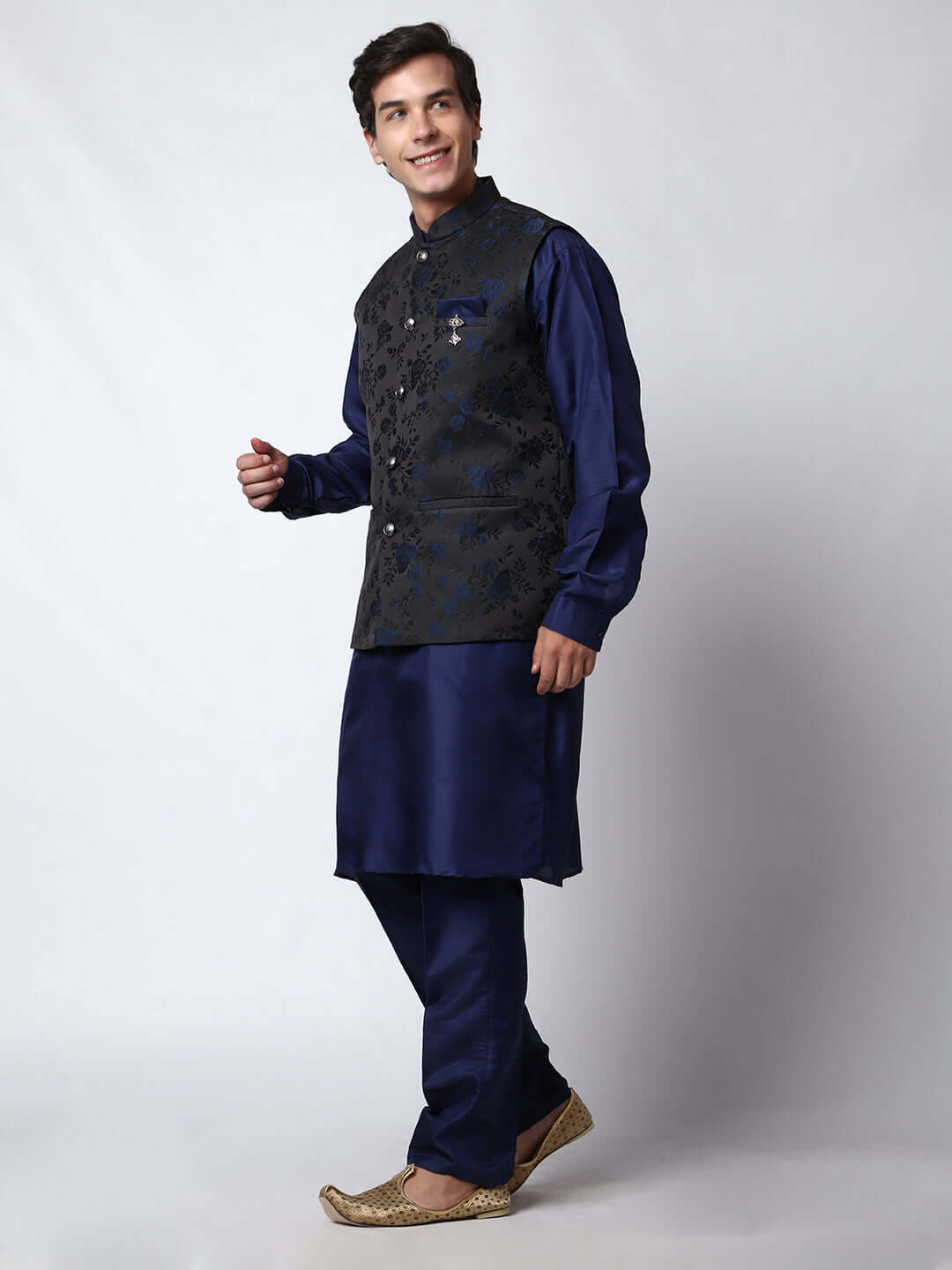 Navy Blue kurta jacket set for men available online in India. An elegant men's ethnic wear kurta jacket set with intricate floral work on black jacquard silk jacket. The black jacket boasts a mandarin collar and complements the navy blue kurta and pants, crafted from smooth cotton silk. This navy blue designer kurta jacket set for men is ideal for weddings, Diwali, Eid, Navratri, & other traditional events. Shop this navy blue designer kurta set for men on Crease India Website.