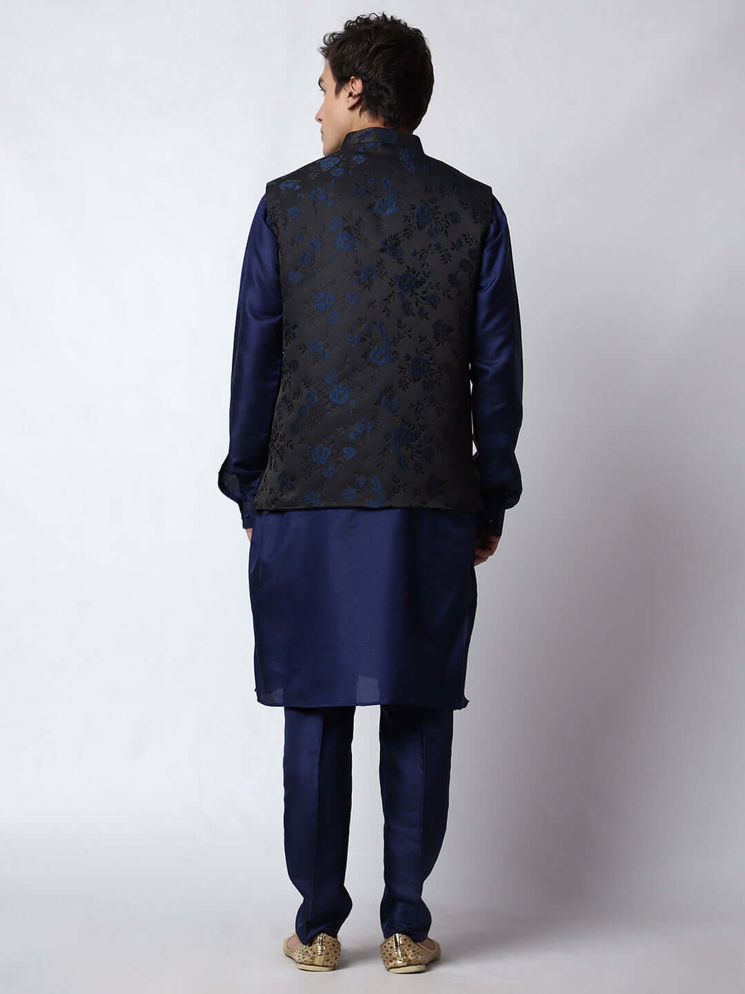 Navy Blue kurta jacket set for men available online in India. An elegant men's ethnic wear kurta jacket set with intricate floral work on black jacquard silk jacket. The black jacket boasts a mandarin collar and complements the navy blue kurta and pants, crafted from smooth cotton silk. This navy blue designer kurta jacket set for men is ideal for weddings, Diwali, Eid, Navratri, & other traditional events. Shop this navy blue designer kurta set for men on Crease India Website.