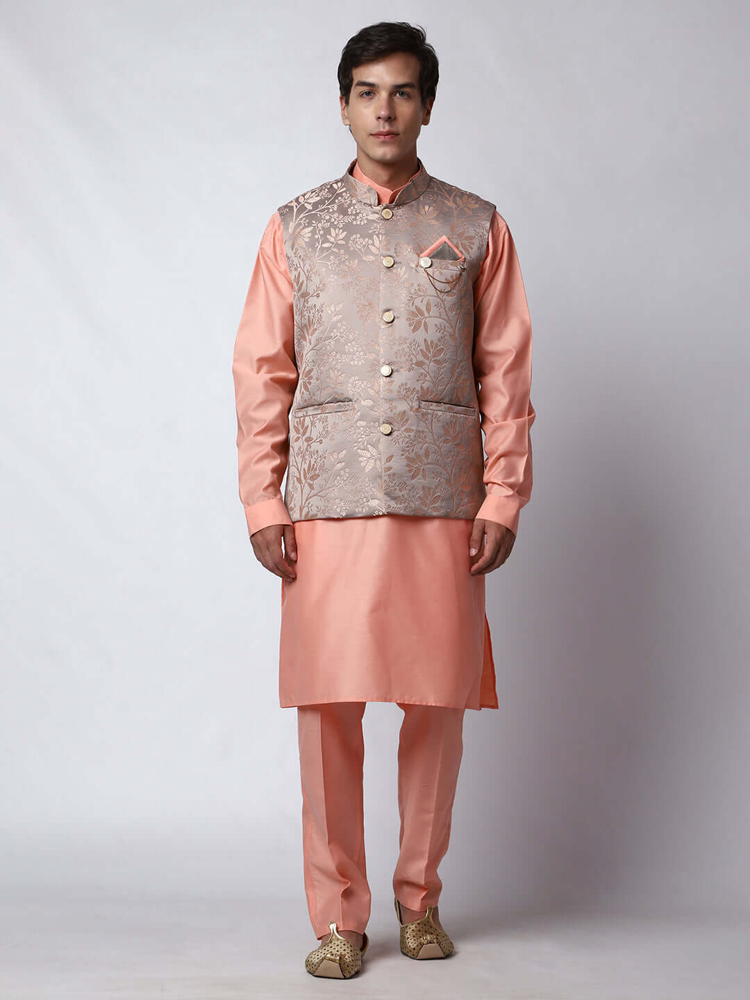 Peach kurta jacket set for men available online in India. An elegant men's ethnic wear kurta jacket set with intricate peach floral embroidery design on grey satin jacquard jacket. The grey satin jacquard jacket boasts a mandarin collar and complements the peach kurta and pants, crafted from smooth cotton silk. This designer peach satin jacquard kurta jacket set for men is ideal for weddings, Diwali, Eid, Navratri, & more festivals. Shop this designer peach kurta set for men at Crease India Website