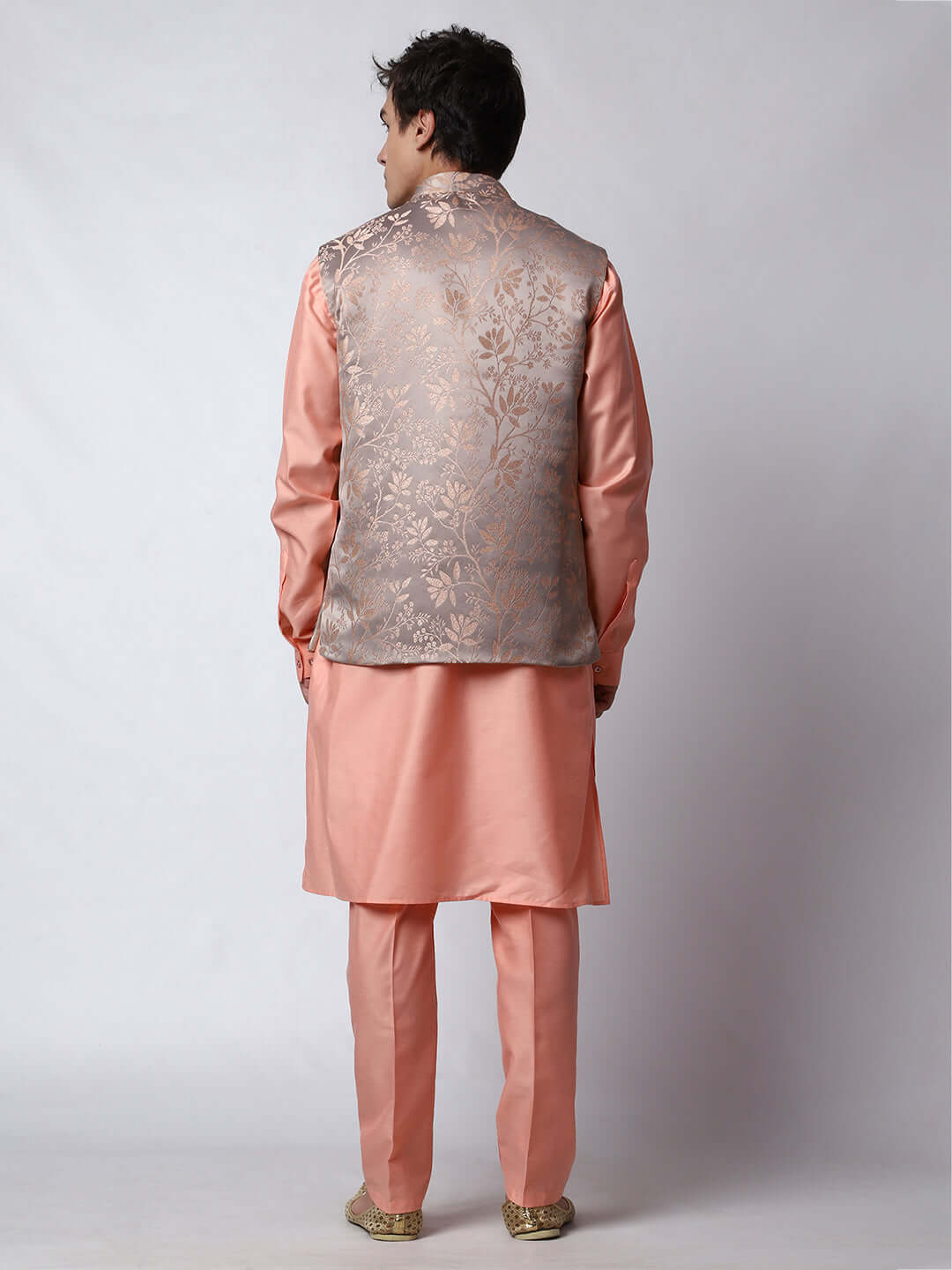 Peach kurta jacket set for men available online in India. An elegant men's ethnic wear kurta jacket set with intricate peach floral embroidery design on grey satin jacquard jacket. The grey satin jacquard jacket boasts a mandarin collar and complements the peach kurta and pants, crafted from smooth cotton silk. This designer peach satin jacquard kurta jacket set for men is ideal for weddings, Diwali, Eid, Navratri, & more festivals. Shop this designer peach kurta set for men at Crease India Website