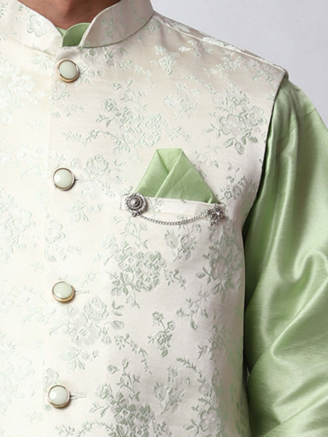 Pista Green kurta jacket set for men available online in India. An elegant men's ethnic wear kurta jacket set with intricate floral embroidery on white jacquard jacket. The white jacquard jacket boasts a mandarin collar and complements the pista green kurta and pants, crafted from smooth dupion silk. This pista green designer kurta jacket set for men is ideal for weddings, Diwali, Eid, Navratri, & more festivals. Shop this pista green designer kurta set for men on Crease India Website.